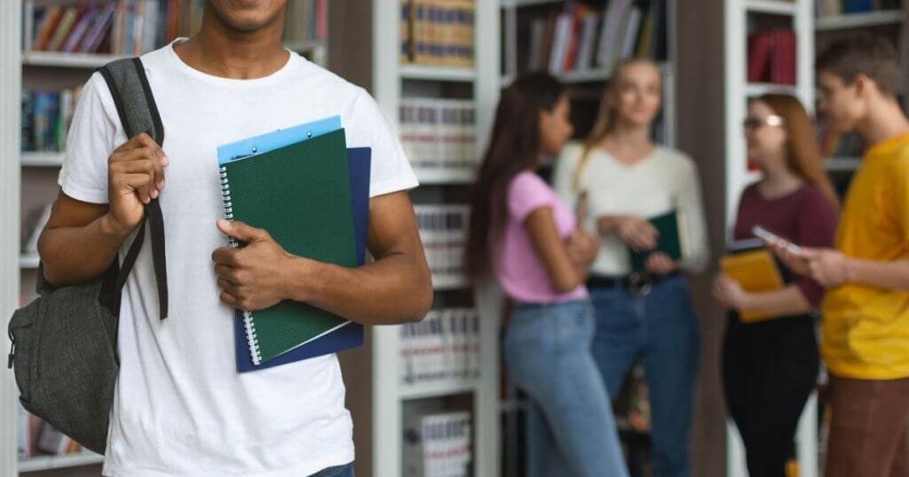 estudante em pé na frente de grupo de outros alunos - Novo Ensino Médio