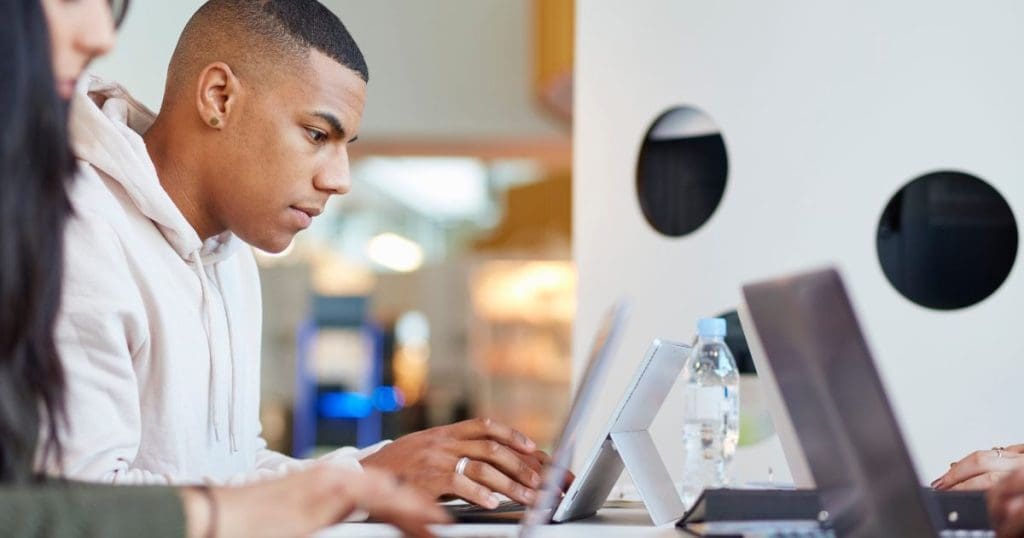 Estágio no Curso Técnico - Estudantes universitários usando laptops e tablets digitais, trabalhando juntos