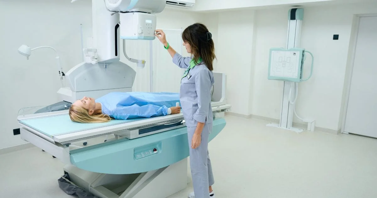 Qual área da Radiologia paga mais? - Técnico em radiologia qualificado preparando mulher para radiografia